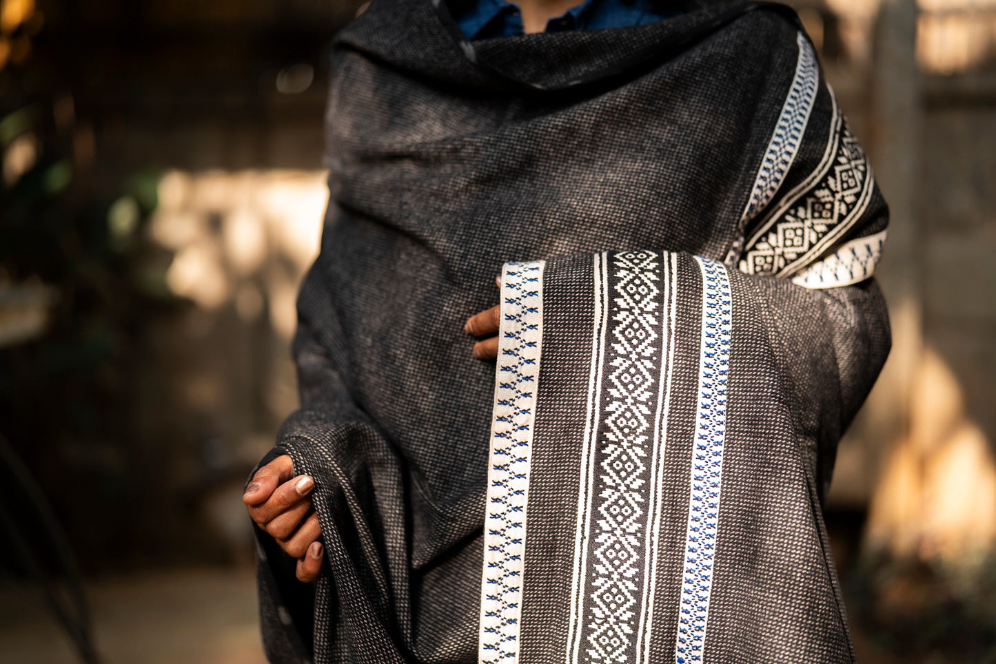 Draped view of Winter Weave Sun shawl showing sun motif borders