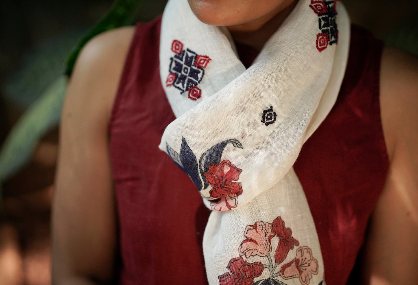 Close-up of Jaipur hand block print rhododendron motif with scattered Toda pukhoor embroidery in navy and red
