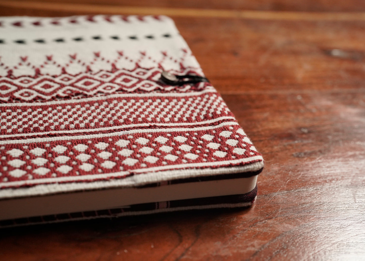 Detail of Toda pukhoor embroidery on red Nilgiri Journal sleeve, no two alike, Nilgiris artisan