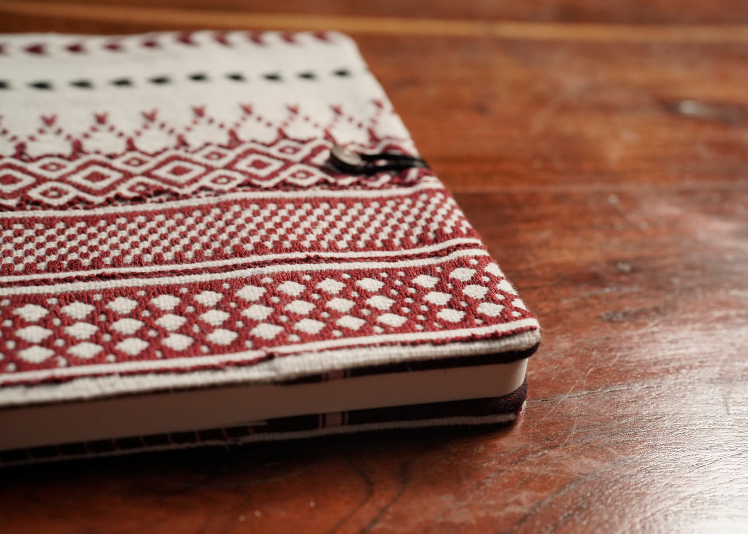 Detail of Toda pukhoor embroidery on red Nilgiri Journal sleeve, no two alike, Nilgiris artisan