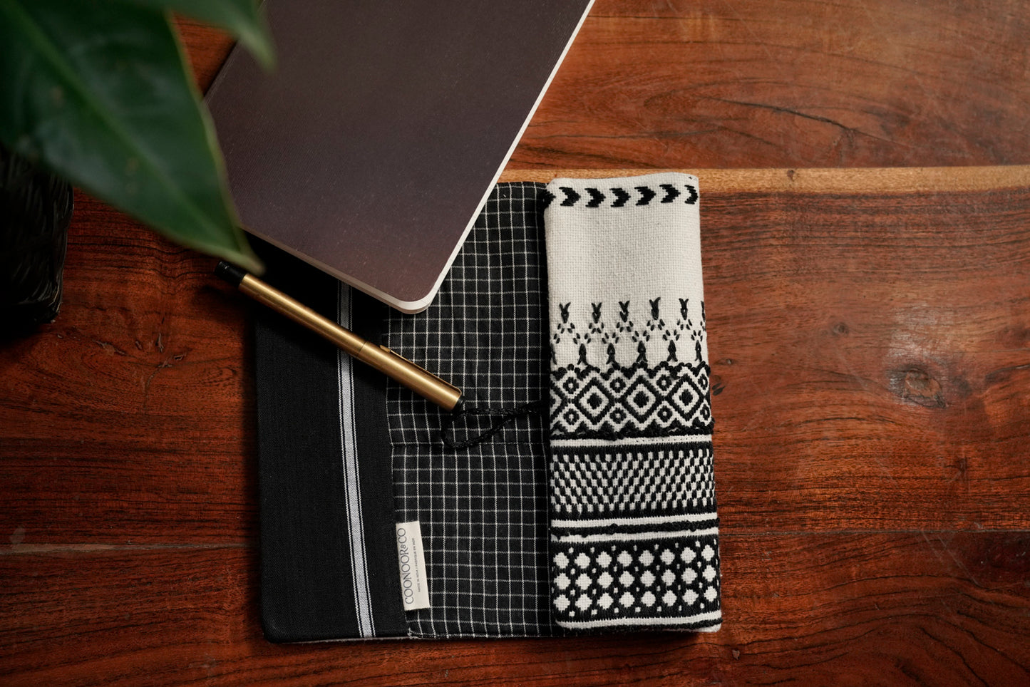 Detail of Toda pukhoor embroidery on black Nilgiri Journal sleeve, minimal, elegant, Nilgiris artisan