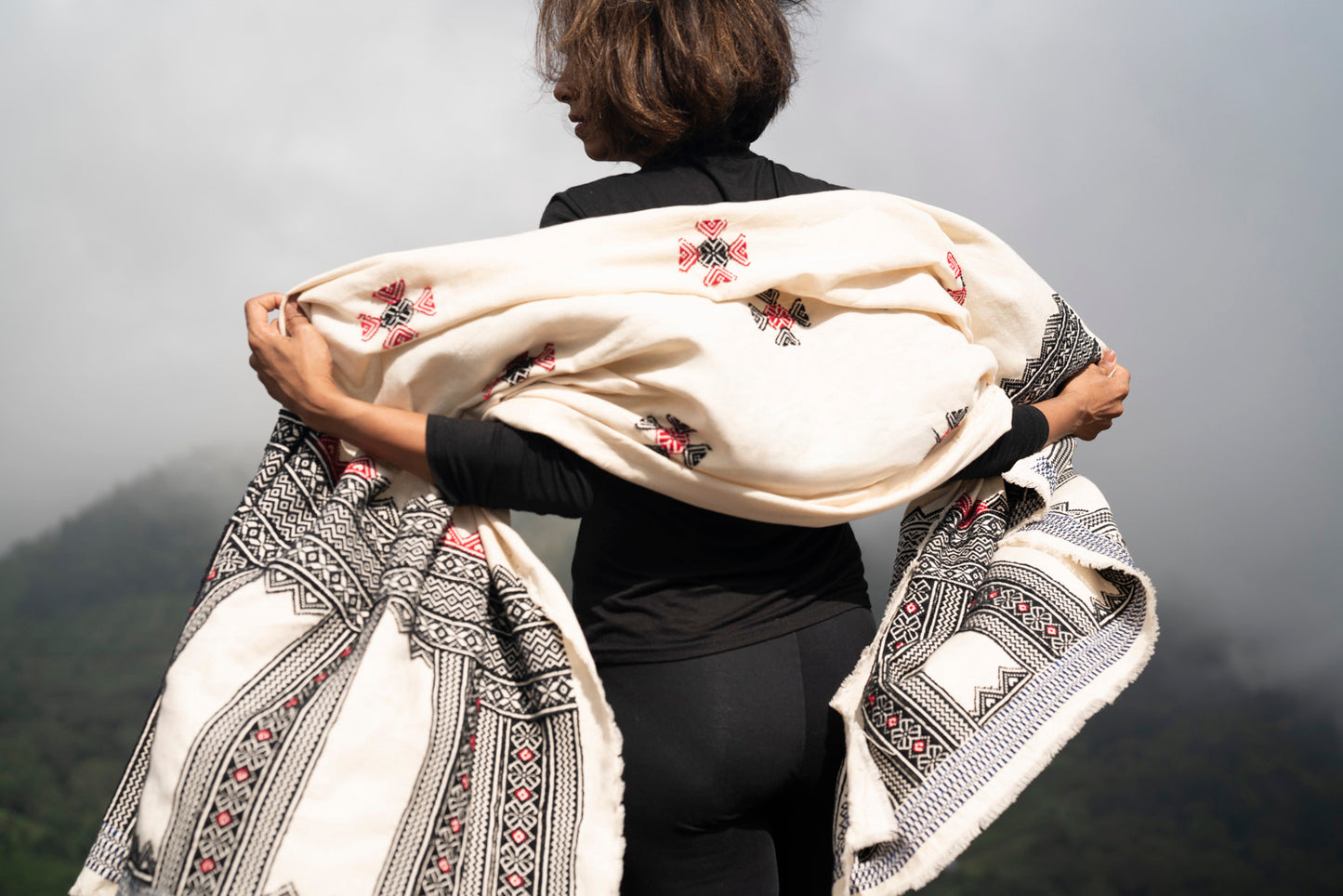 Detail of Toda pukhoor embroidery on Windsong shawl, forest and mountain motifs in black and red