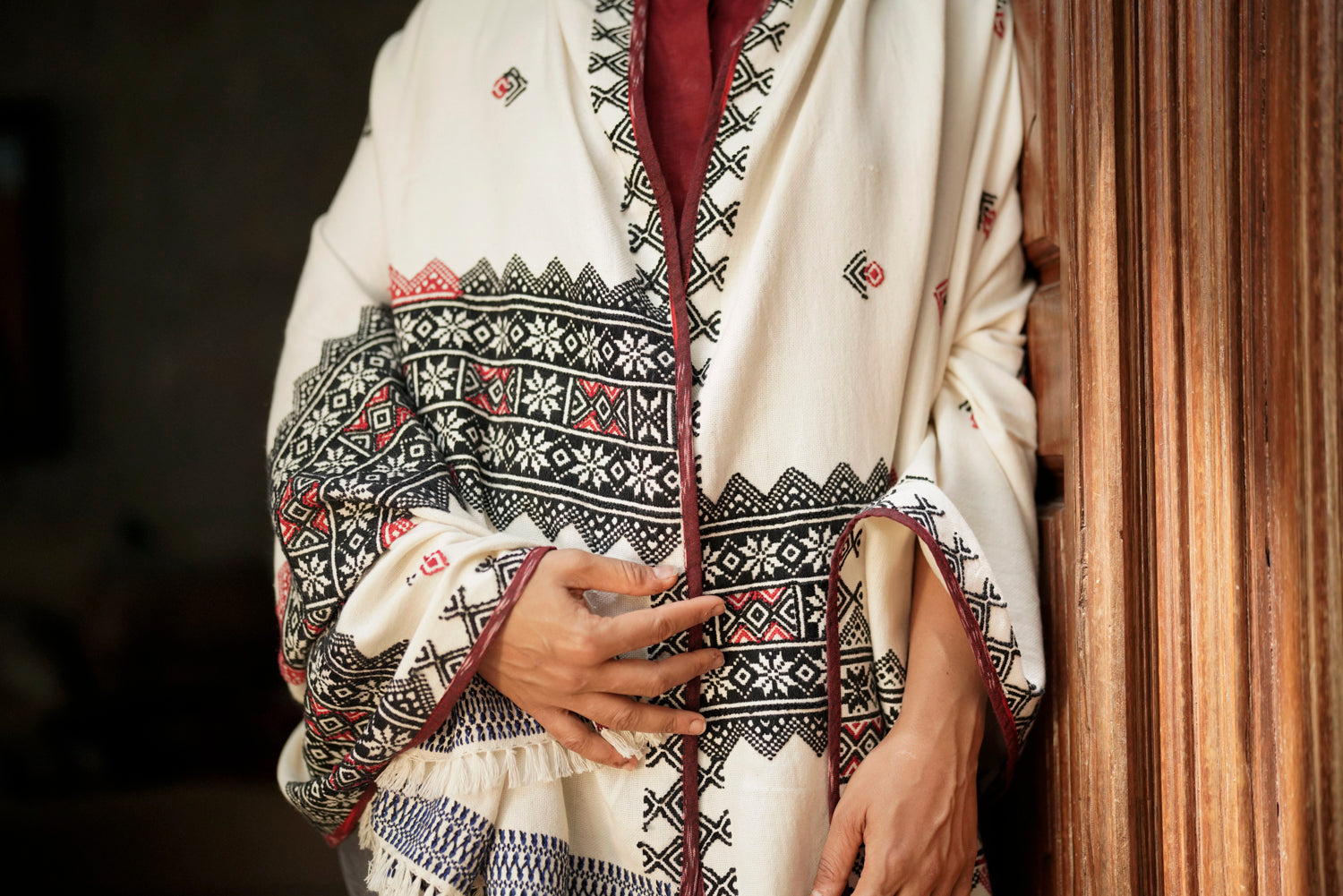 Detail of black and red Toda pukhoor embroidery on Mawshh shawl, mountain and botanical motifs