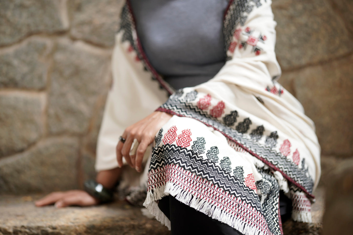 Close-up of sacred grove Toda pukhoor embroidery in black and red on cotton shawl